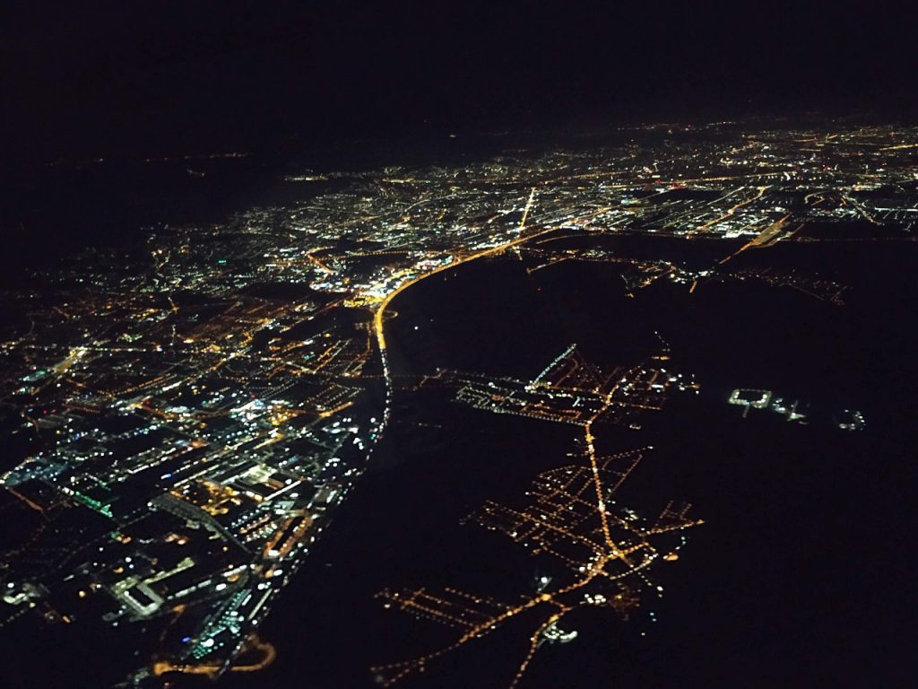 luftaufnahme nachts, zu sehen sind beleuchtete Straßen und Städte