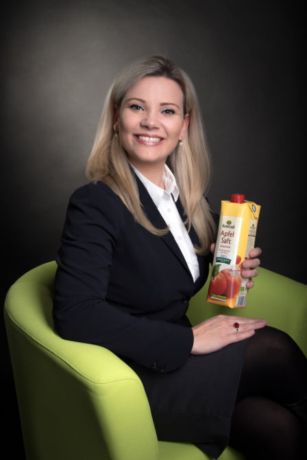 businessfoto melanie kollmann-alnatura gmbh, auf grünem stuhl mit apfelsaftpackung