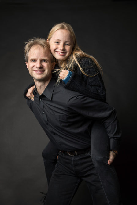 vater mit kuschelnder tochter huckepack