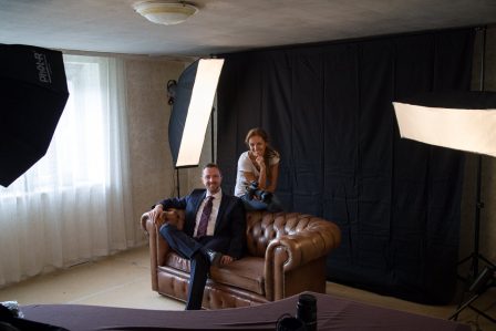 businessfoto mann im blauen anzug sitzt auf chesterfieldcouch